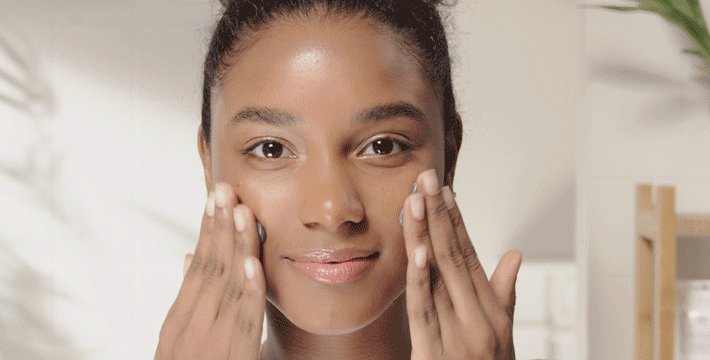 gif of a woman applying the Origins Clear Improvement Charcoal Mask, both hands applying product under both eyes and on cheeks