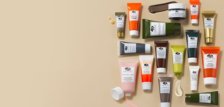 An assortment of Origins mini travel sized skincare on a beige background